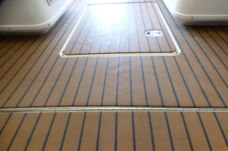 Teak deck of 2002 Sea Ray 340 Amberjack boat, featuring hatch and striped design.