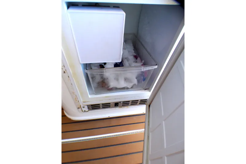 Freezer compartment on 2002 Sea Ray 340 Amberjack boat, containing ice and items.