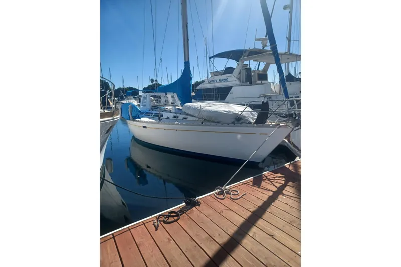 1987 O'Day 40 sailboat docked at marina under clear blue sky.