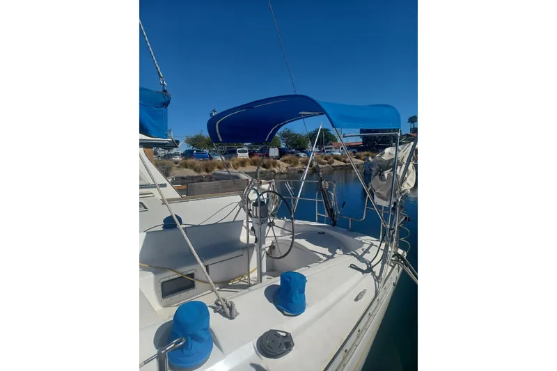1987 O'Day 40 sailboat with blue canopy docked in a marina.