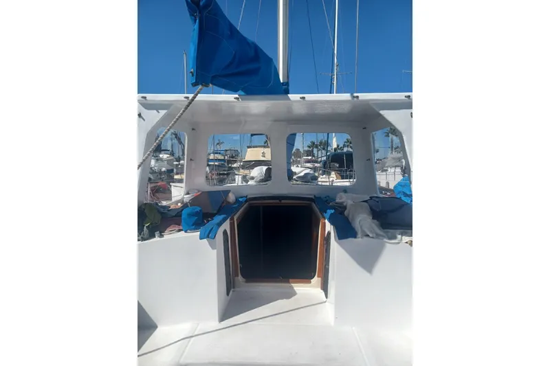 1987 O'Day 40 sailboat cockpit with blue sail cover, marina background.