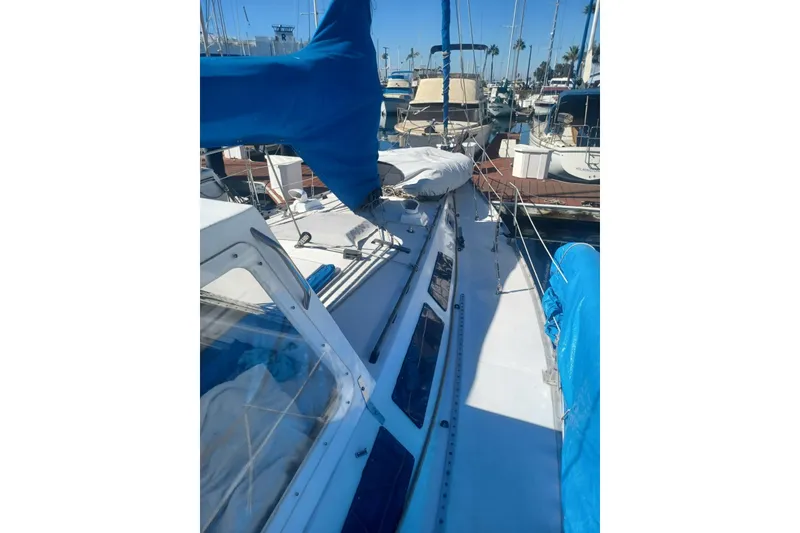 1987 O'Day 40 sailboat docked, featuring blue covers and a sleek white deck.