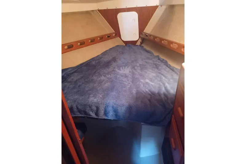 Cozy cabin interior of 1987 O'Day 40 sailboat with blue bedding.