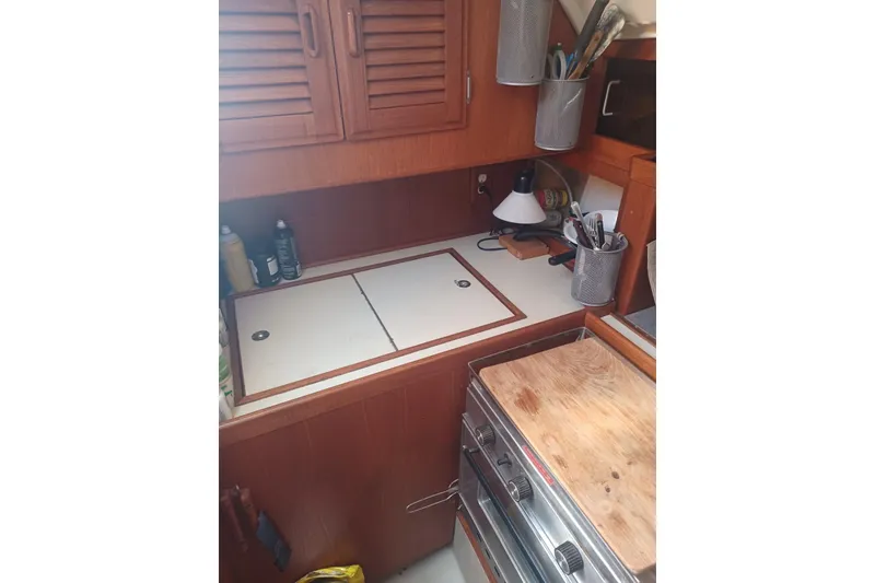 1987 O'Day 40 yacht kitchen with wooden cabinets and stove.