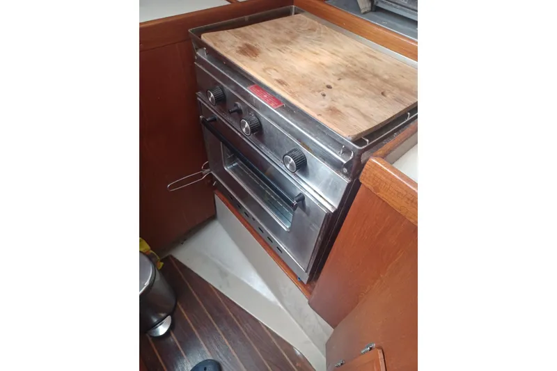 1987 O'Day 40 yacht kitchen with stainless steel oven and wooden countertop.