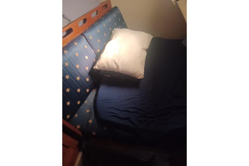 Cozy cabin bed with star-patterned upholstery in 1987 O'Day 40 sailboat.