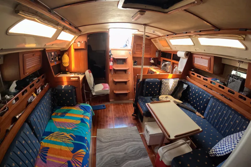 Interior of a 1987 O'Day 40 sailboat with cozy seating and vibrant decor.
