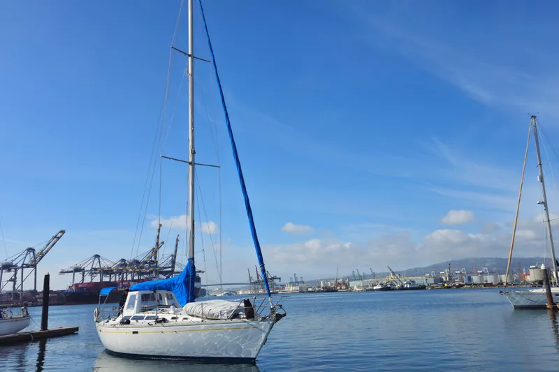 1987 O'Day 40 sailboat docked in a busy harbor under a clear blue sky.