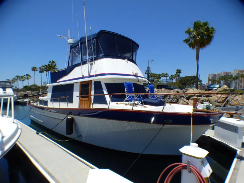 1980 CHB Heritage 42 Trawler docked at marina with blue sky background.