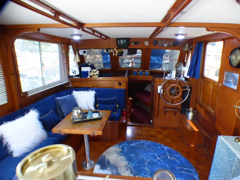 Interior of 1980 CHB Heritage 42 Trawler with wooden finishes and blue seating.