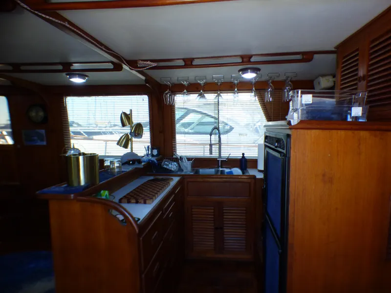 Interior of 1980 CHB Heritage 42 Trawler kitchen with wooden cabinets and appliances.