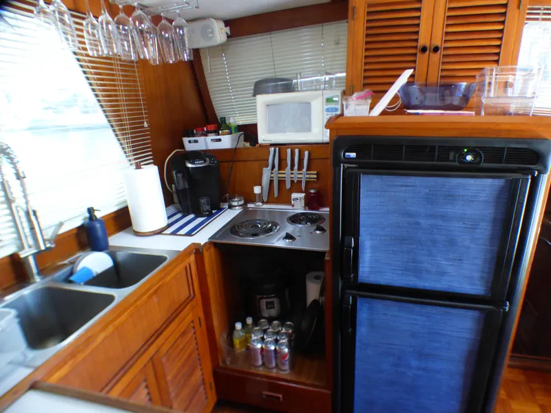 1980 CHB Heritage 42 Trawler kitchen with stove, sink, fridge, and microwave.