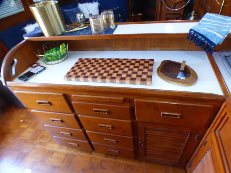 1980 CHB Heritage 42 Trawler kitchen with wooden cabinets and cutting boards.