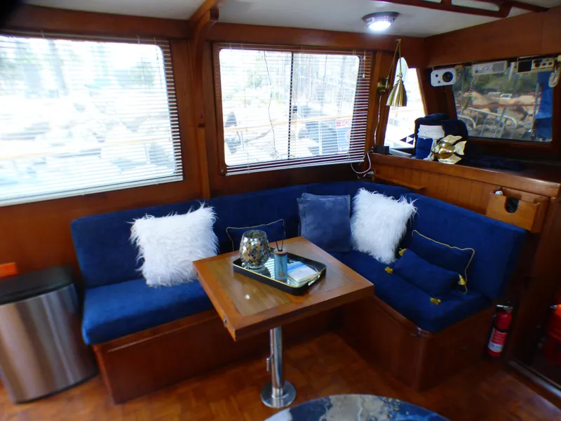 Interior of 1980 CHB Heritage 42 Trawler with blue seating and wooden table.