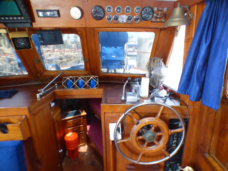 1980 CHB Heritage 42 Trawler helm with wooden steering wheel and navigation instruments.
