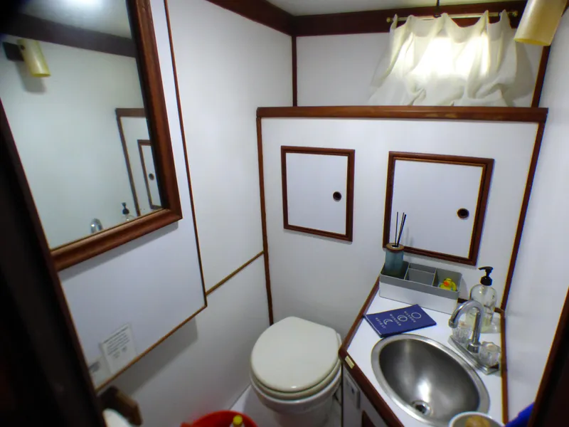 1980 CHB Heritage 42 Trawler bathroom with sink, toilet, and storage cabinets.
