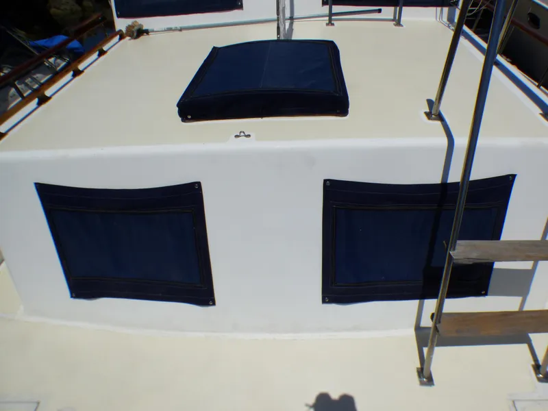 1980 CHB Heritage 42 Trawler deck with blue canvas covers and ladder.