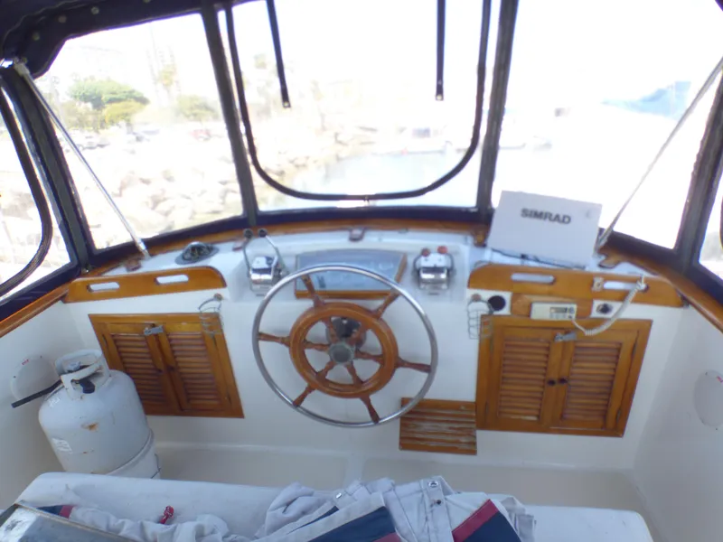 1980 CHB Heritage 42 Trawler helm with wooden wheel and navigation equipment.