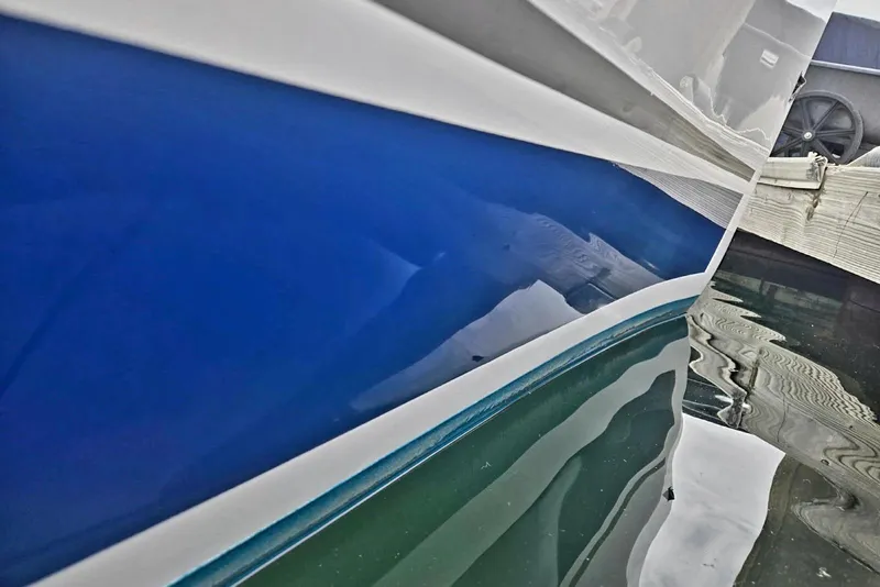 Close-up of a 2012 Hunter 36 boat hull reflecting in water.