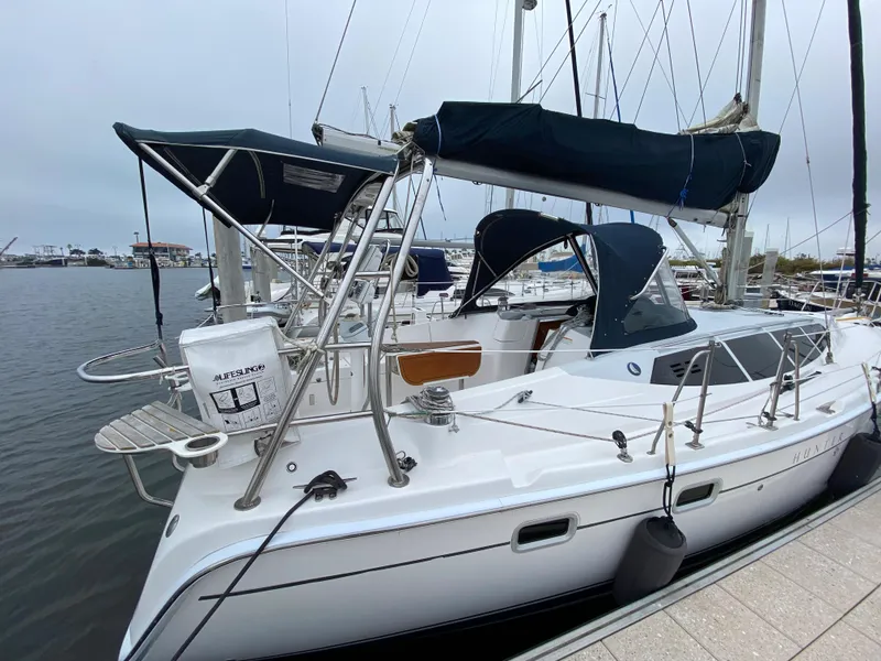 2012 Hunter e36 sailboat docked at marina with black canopy.