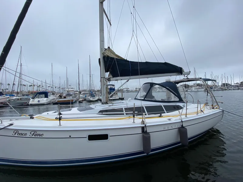 2012 Hunter e36 sailboat docked in a marina on a cloudy day.