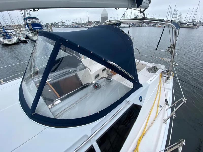 Hunter e36 2012 sailboat with blue canopy docked at marina.