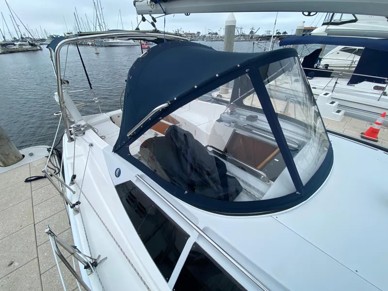 2012 Hunter e36 sailboat docked at marina with blue canopy.