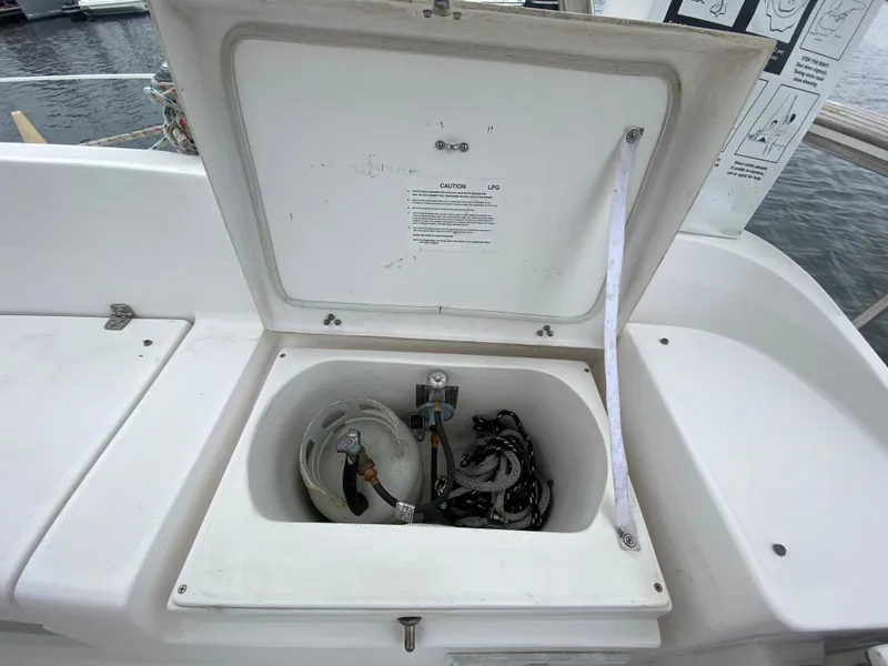 Open storage compartment on a 2012 Hunter e36 sailboat, containing a propane tank and ropes.