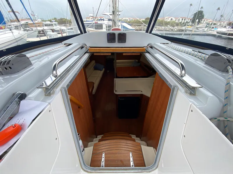 Interior view of 2012 Hunter e36 sailboat cabin with wooden stairs and seating area.