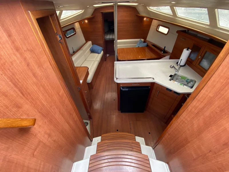 Interior of 2012 Hunter e36 sailboat with wooden finishes, kitchen, and seating area.
