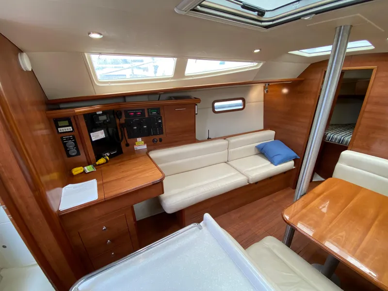 Interior of 2012 Hunter e36 sailboat with wooden furnishings and white seating.