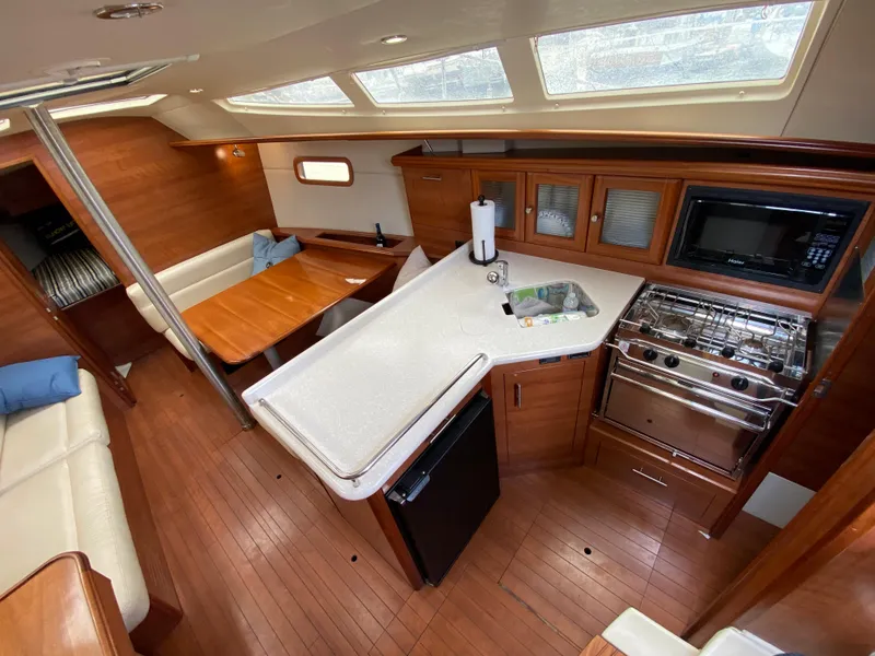 Interior of 2012 Hunter e36 sailboat with kitchen, dining area, and wooden finishes.