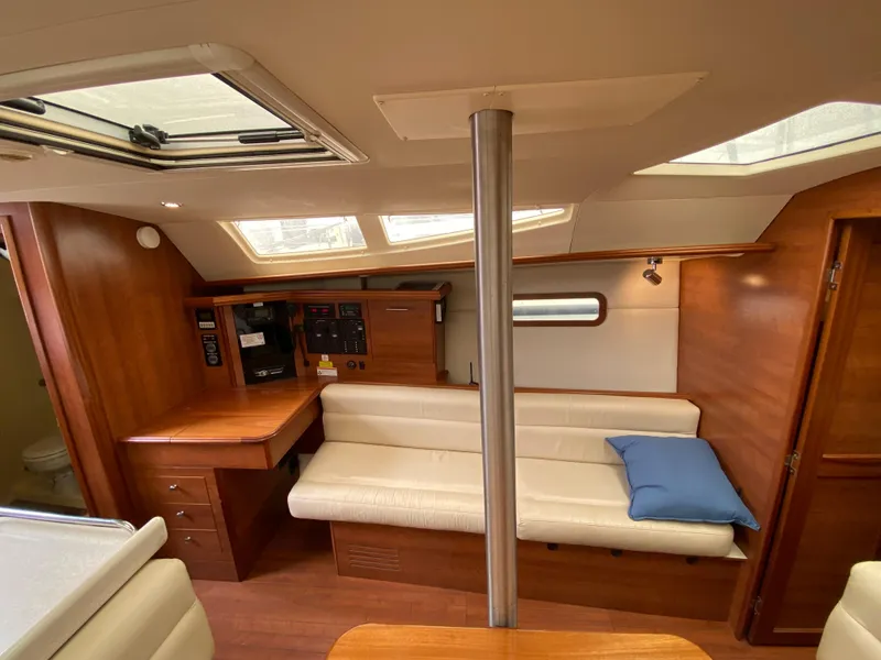 Interior of 2012 Hunter e36 sailboat with wooden cabinetry and white seating.