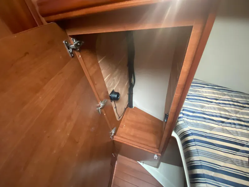 Open wooden cabinet in a 2012 Hunter e36 boat interior.