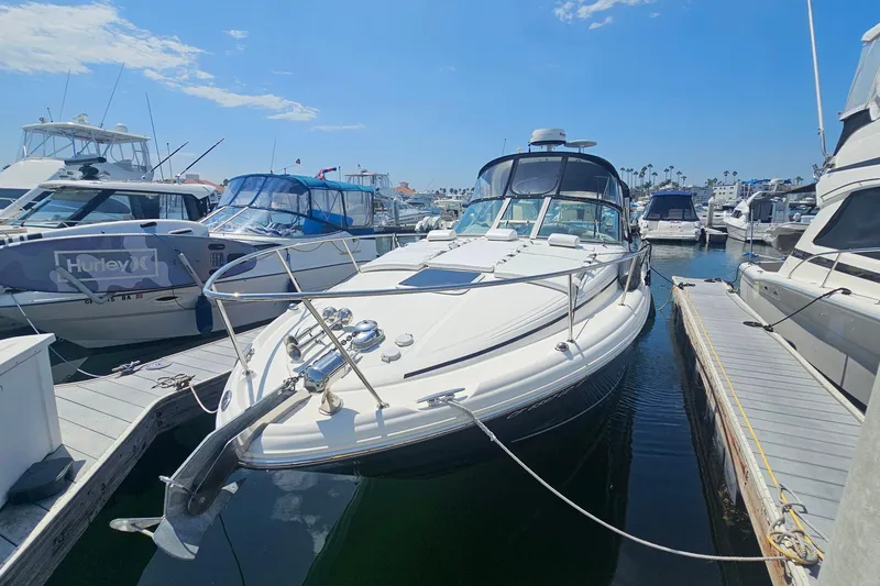 2005 Sea Ray 300 Sundancer docked at marina under clear blue sky.