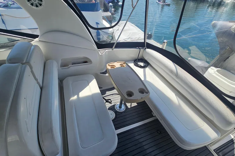 2005 Sea Ray 300 Sundancer interior with seating and table, docked by the water.