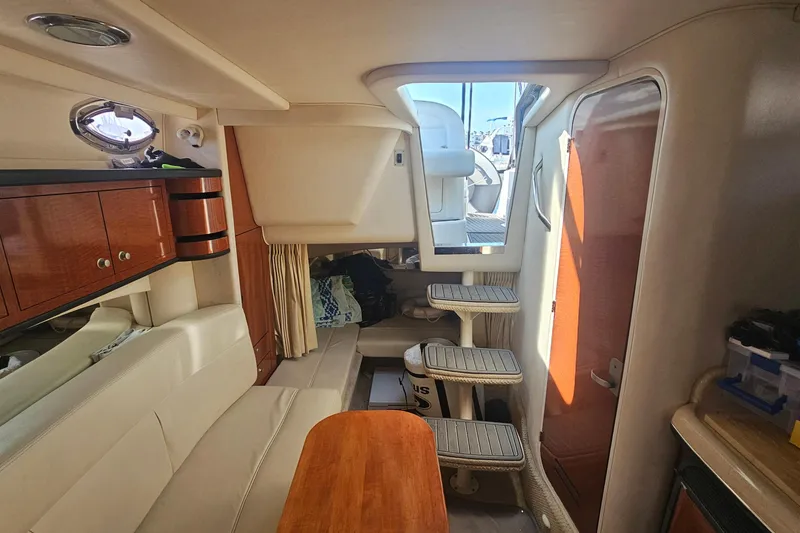 Interior of 2005 Sea Ray 300 Sundancer boat with seating and wooden cabinetry.