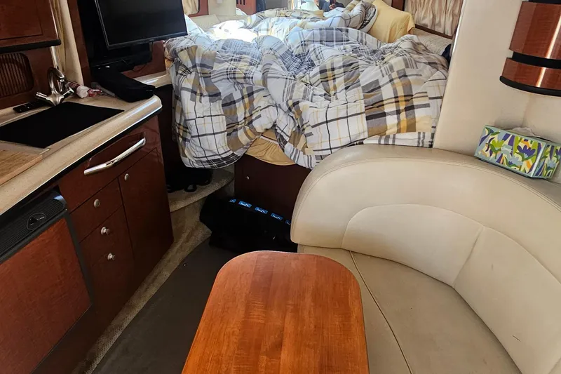 Interior of 2005 Sea Ray 300 Sundancer with cozy bed and kitchenette.