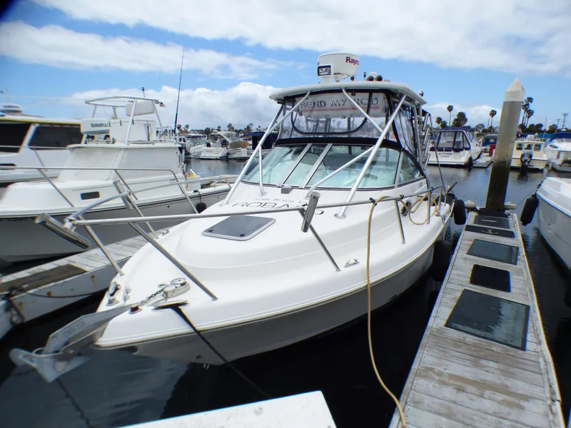 2004 Robalo R265 Walkaround boat docked at marina under cloudy sky.