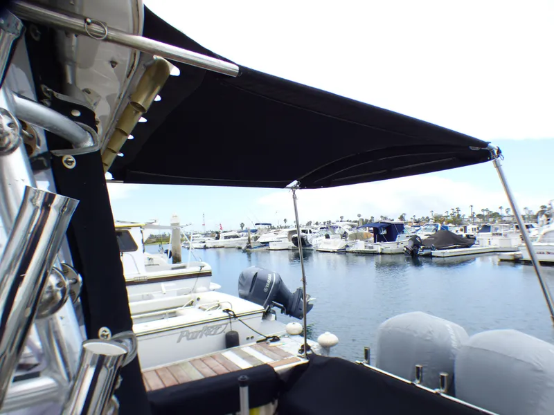 2004 Robalo R265 Walkaround boat docked at marina with black canopy.