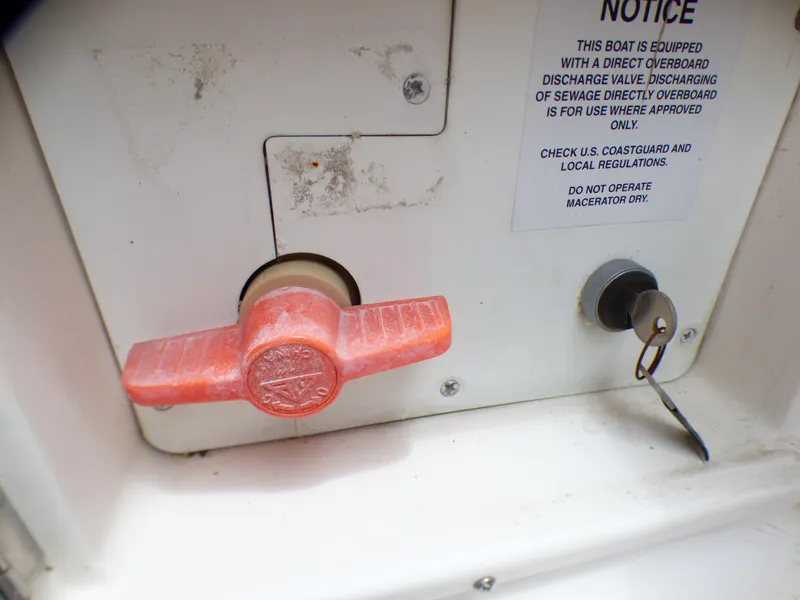2004 Robalo R265 Walkaround boat discharge valve with safety notice and key lock.