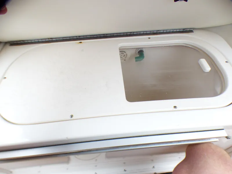 2004 Robalo R265 Walkaround boat compartment with transparent lid and visible latch.