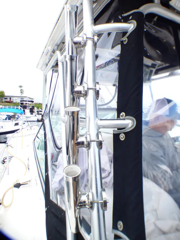 2004 Robalo R265 Walkaround boat with stainless steel rod holders and protective canopy.