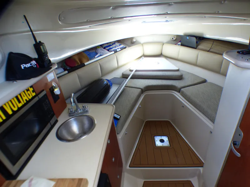 2004 Robalo R265 Walkaround cabin interior with kitchenette, seating, and storage.