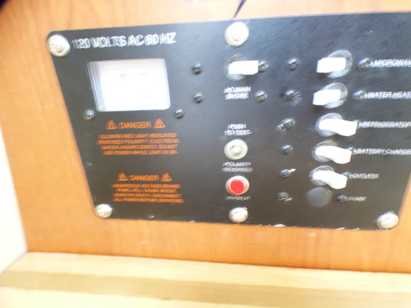 Control panel of a 2004 Robalo R265 Walkaround boat, showing electrical switches and warnings.