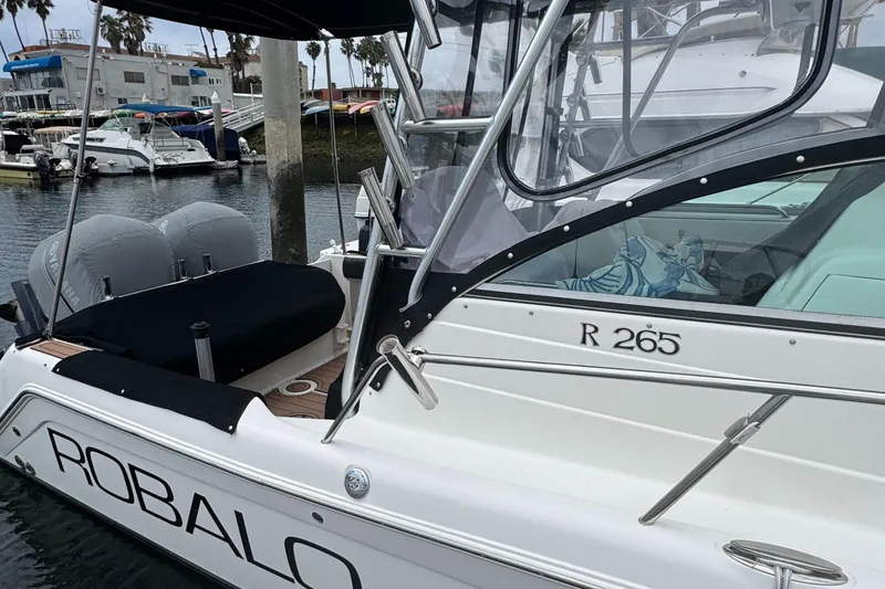 2004 Robalo R265 Walkaround boat docked in marina, featuring sleek design and sturdy build.