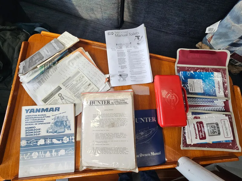 Sailboat manuals and accessories on a table, Hunter Legend 35, 1988.