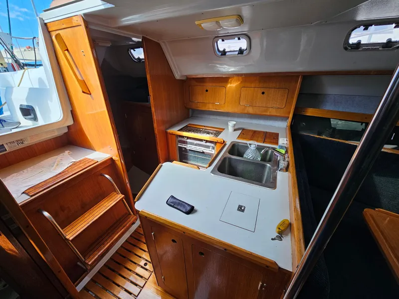 Interior of a 1988 Hunter Legend 35 yacht with kitchen and wood paneling.