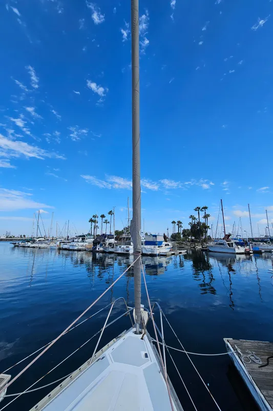 Sailboat Hunter Legend 35 in harbor, blue sky, calm water.