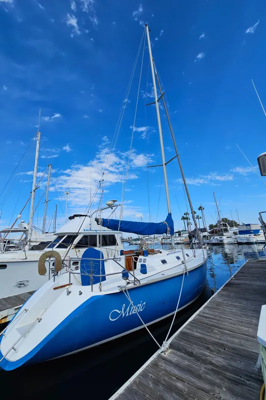 1988 Hunter Legend 35 sailboat docked under blue sky.